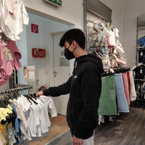 Schüler hängt Kleidung auf