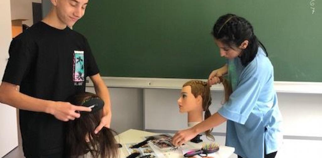 Mädchen und Bursche mit Frisurenkopf